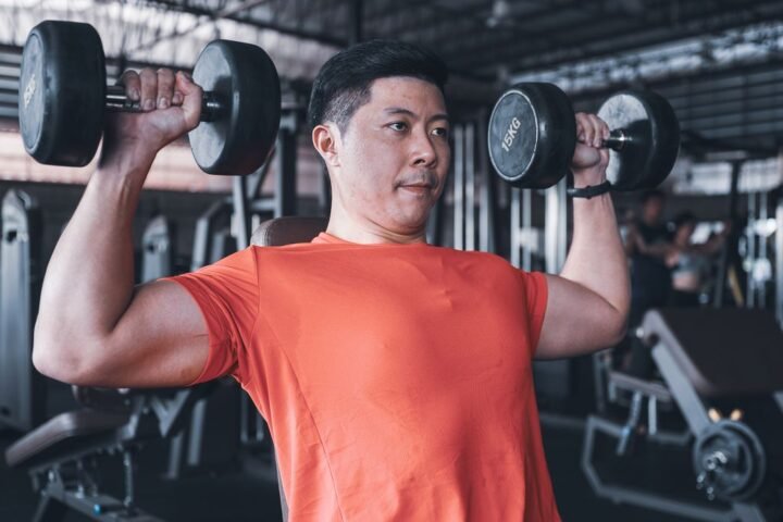 Man performing dumbbell shoulder press